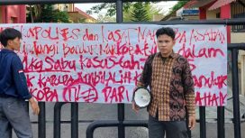 Nampak aktivis GMPSU membentangkan kain putih pada gerbang pintu Polres Asahan bertuliskan desakan untuk pengusutan kasus jaringan Narkotika di Sumatera Utara. ©timeskota.com/M. Idris Sarumpaet