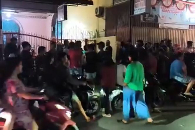 
 Warga berkumpul di depan rumah kos saat kabar ditemukannya seorang wanita meninggal dunia di dalam kamar kos tersebut menghebohkan lingkungan sekitar.