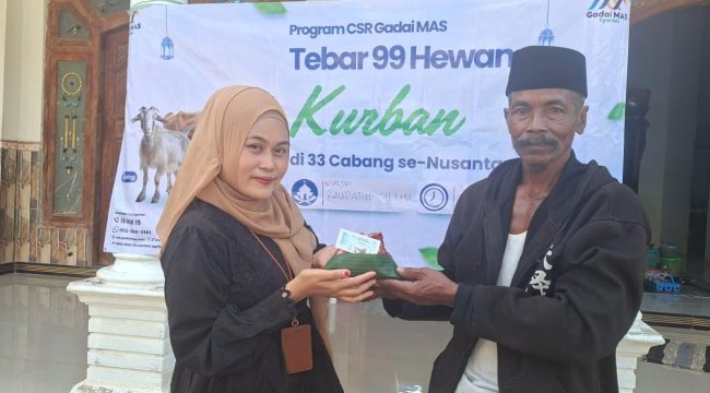Foro.Kepala Cabang Sumenep Gadai Mas Nusantara Ingmatuz Zahroh saat memberikan daging sapi kurban yang berbungkus daun ke penerima manfaat